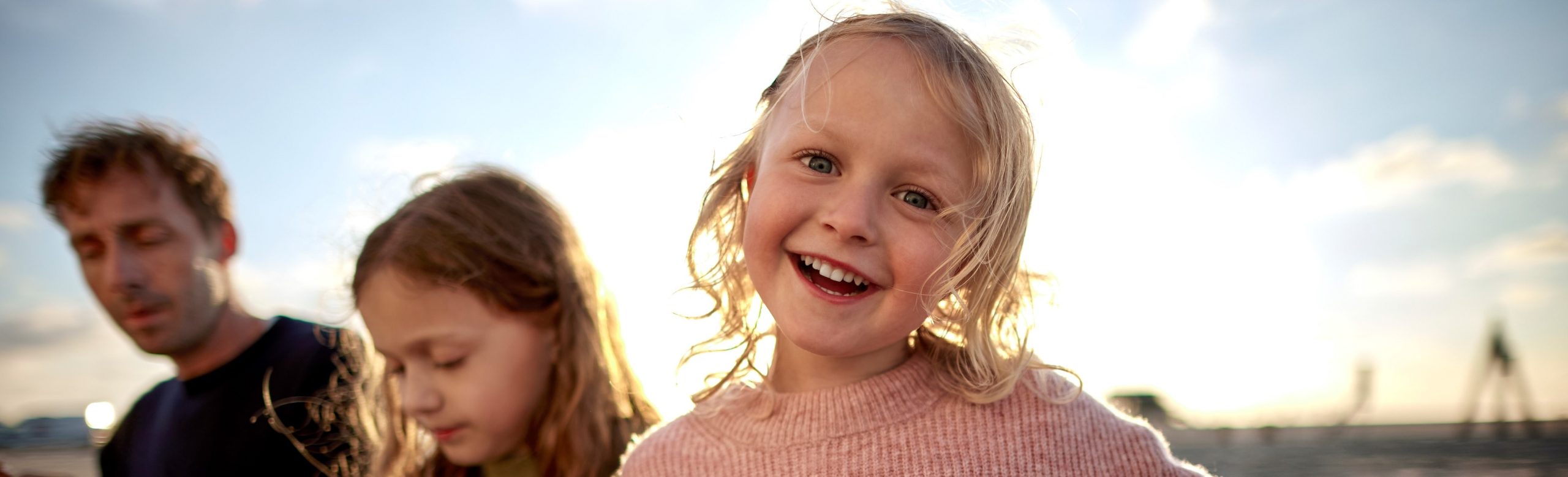 Petite fille heureuse sur une plage avec sa famille